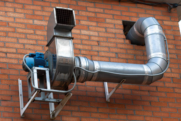 External engine of the building's exhaust system structure, mounted on a vertical brick wall.